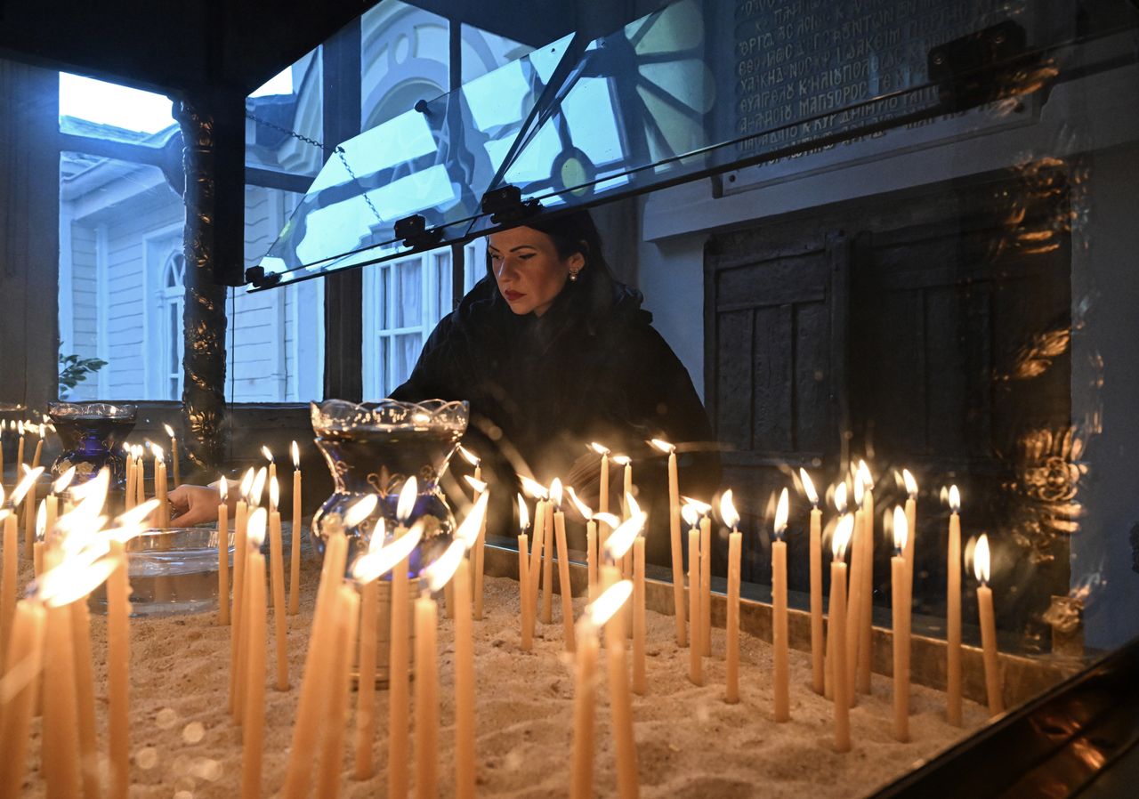 Γυναίκα ανάβει ευλαβικά ένα κερί στο Οικουμενικό Πατριαρχείο της Κωνσταντινούπολης. 