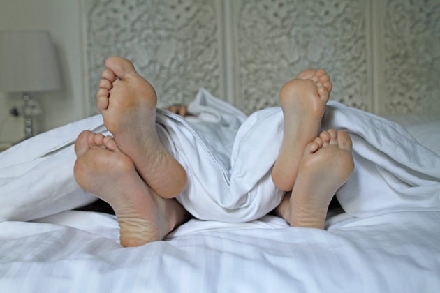 Couple's feet under a blanket