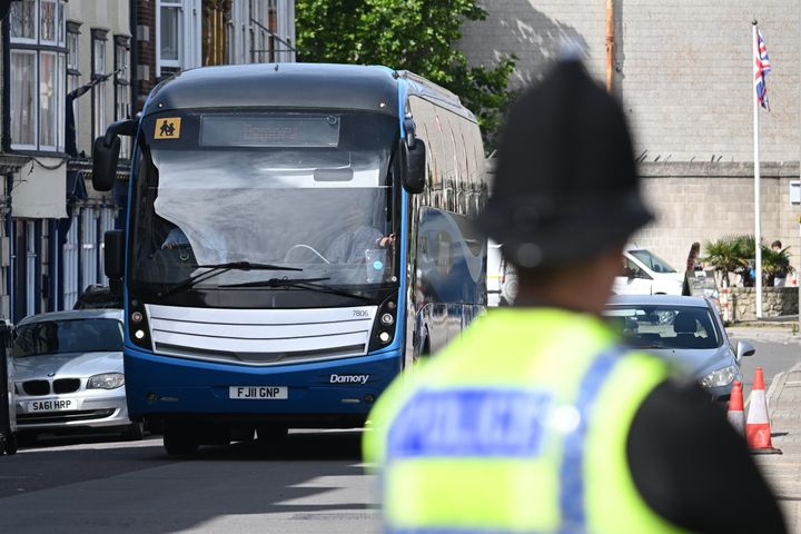 PORTLAND, ENGLAND - AUGUST 7: A coach arrives at the front gates as the migrant barge 'Bibby Stockholm' prepares to welcome its first asylum seekers on August 7, 2023 in Portland, England. Approximately 50 arrivals are set to board the Bibby Stockholm, moored at Portland in Dorset, as part of the Home Office's plan to accommodate up to 500 migrants on the vessel. The barge is equipped with amenities like a TV room, multi-faith prayer room, classroom, gym, and outdoor recreational space, ensuring it offers 24-hour security and healthcare provision. Addressing concerns raised by the firefighters' union, Immigration Minister Robert Jenrick last week assured the public that the Bibby Stockholm is a "safe facility." (Photo by Finnbarr Webster/Getty Images)