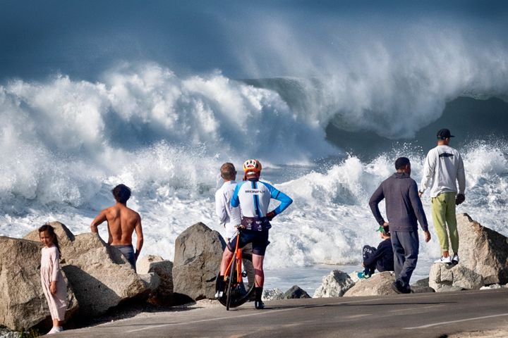 Beachgoers watch as turbulent surf pounds the coast at Manhattan Beach on Thursday, Dec. 28, 2023 in Manhattan Beach, Calif. (AP Photo/Richard Vogel)