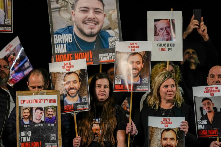 Families and supporters of Israeli hostages held by Hamas in Gaza hold their photos and shout slogans during a rally calling for their release, in Tel Aviv, Israel, Saturday, Dec. 30, 2023. More than 100 Israeli hostages are held in Gaza after being abducted in a Hamas cross-border attack on Oct. 7. (AP Photo/Ariel Schalit)