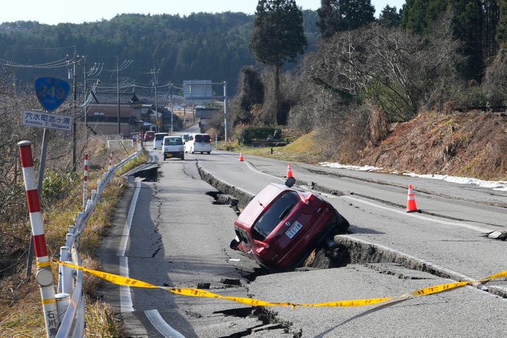 A car is trapped at a partially collapsed road caused by a powerful earthquake near Anamizu Town, Ishikawa Prefecture on Jan. 2, 2024. A series of powerful earthquakes hit western Japan, damaging buildings, vehicles and boats, with officials warning people in some areas on Tuesday to stay away from their homes because of a risk of more strong quakes.