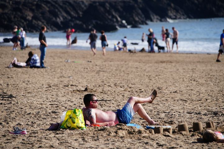 People enjoy the warm weather on the beach at Barry Island in the Vale of Glamorgan, South Wales. 