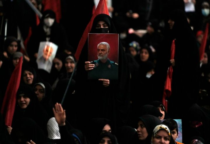 Μια γυναίκα κρατάει μια αφίσα του αείμνηστου στρατηγού των Φρουρών της Επανάστασης Qassem Soleimani, ο οποίος σκοτώθηκε σε επίθεση αμερικανικού μη επανδρωμένου αεροσκάφους το 2020 στο Ιράκ, κατά τη διάρκεια μιας εκδήλωσης μνήμης γι' αυτόν στο μεγάλο τζαμί Ιμάμ Χομεϊνί στην Τεχεράνη, Ιράν, Τετάρτη, 3 Ιανουαρίου 2024.