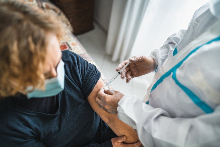 doctor doing the covid 19 vaccine at home for omicron variant