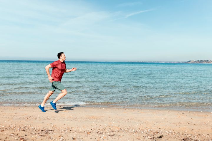 Active man running by the sea