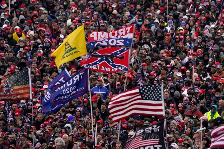 People listen as Trump speaks during a rally that morphed into an attack on the U.S. Capitol. 