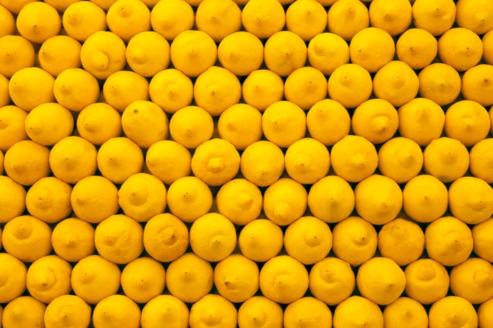 Bright yellow lemons stacked neatly at supermarket.