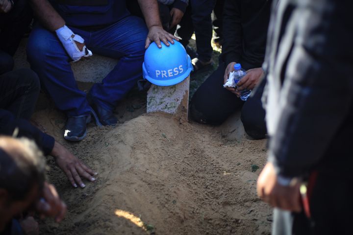 A press helmet is placed over the grave of Hamza Dahdouh.