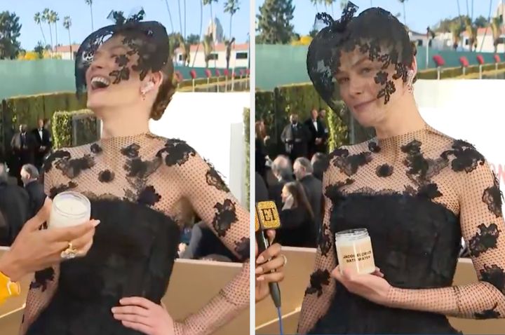 Rosamund Pike poses with a "Jacob Elordi's Bath Water" candle at the Golden Globes