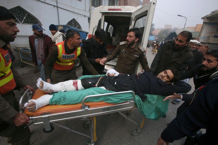 Εργαζόμενοι διάσωσης και εθελοντές μεταφέρουν έναν τραυματισμένο αστυνομικό, θύμα βομβιστικής επίθεσης κατά την άφιξή του σε νοσοκομείο στην Πεσαβάρ του Πακιστάν (8/1/2024).