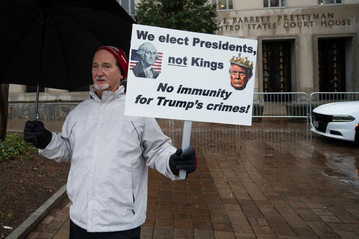 Protesters stand outside during a hearing on immunity for former President Donald Trump.