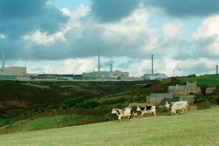 In the background, the COGEMA factory rises from the landscape. The factory at La Hague specializes in the treatment of used nuclear fuels discarded from reactors owned by French, European and Asian electrical companies. The treatment consists of separating, then packaging the different components, gleaning recyclable fuels, such as Uranium and Plutonium, from non-recyclable components, which contain the majority of the radioactivity, for safe containment.