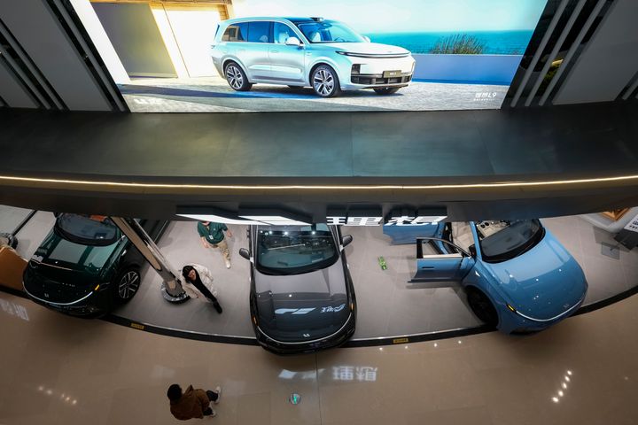 Οι άνθρωποι κοιτάζουν τα μοντέλα αυτοκινήτων Lixiang, μέσα σε ένα εμπορικό κέντρο στο Πεκίνο την Τρίτη, 9 Ιανουαρίου 2024. Οι εξαγωγές αυτοκινήτων της Κίνας αυξήθηκαν κατά 63,7% το 2023, ενώ οι πωλήσεις στο εσωτερικό ενισχύθηκαν επίσης. (AP Photo/Andy Wong)