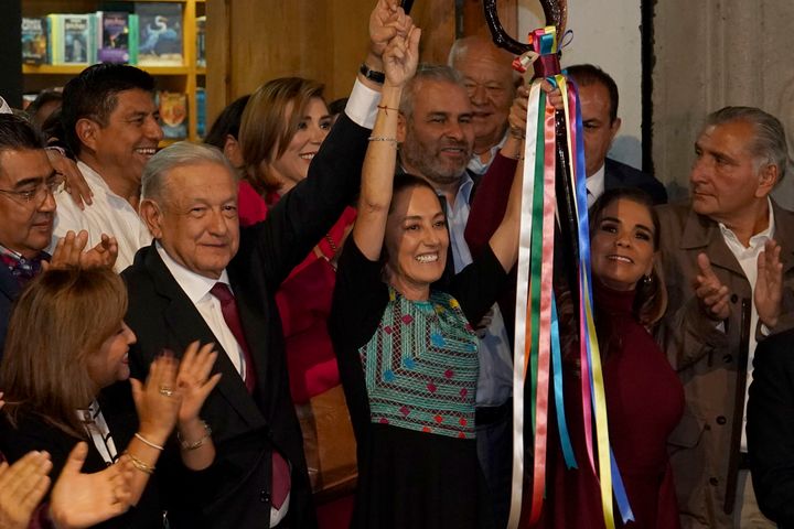 Mexican President Andres Manuel Lopez Obrador raises the hand of Claudia Sheinbaum, the ruling party's candidate for the upcoming presidential elections, during a ceremony to give her the party's command staff on Sept. 7.