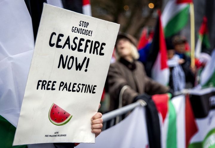 Pro-Palestinian demonstrators shout slogans and wave placards as they stage a rally outside the International Court of Justice (ICJ) in The Hague on January 12, 2024, prior to the hearing of the genocide case against Israel, brought by South Africa. (Photo by KOEN VAN WEEL/ANP/AFP via Getty Images)