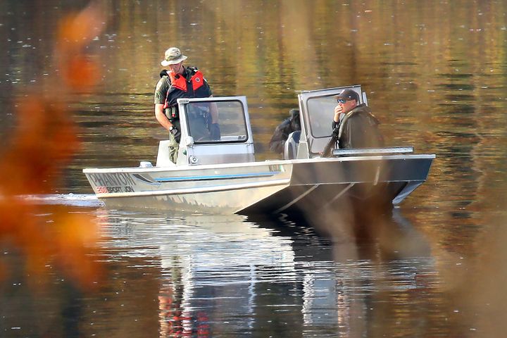 Police in a boat search the Androscoggin River near where Robert Card abandoned his car following the attack.
