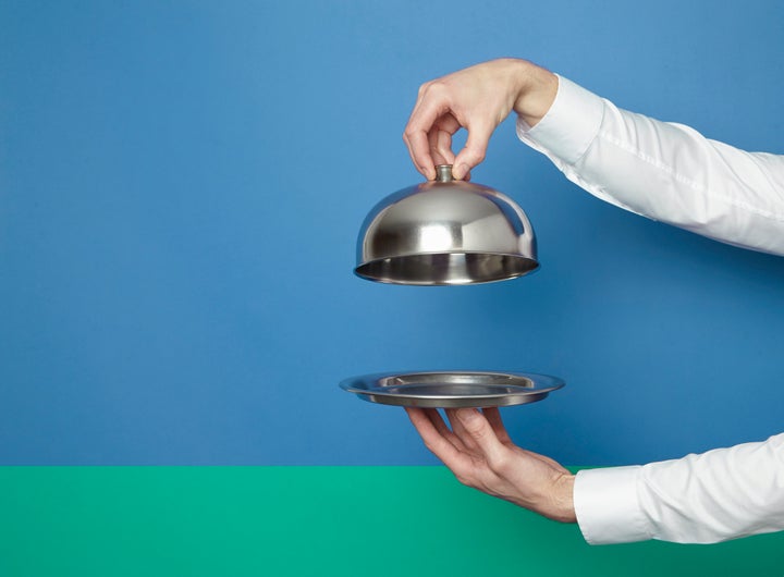 man holding silver tray and lid against blue and green background