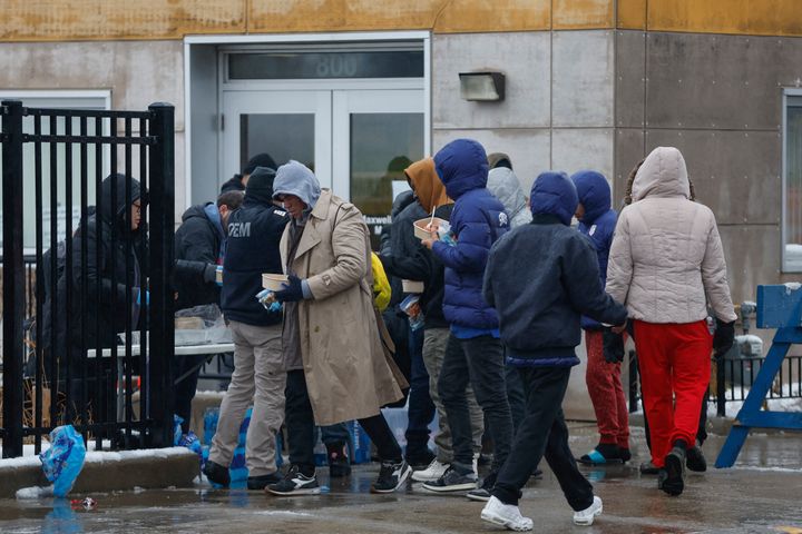 A group of migrants receive food outside a migrant "landing zone" in Chicago on Friday during a winter storm.