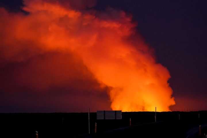 Άποψη του πλουμίου αερίου που φωτίζεται από τη λάβα του εκρηγνυόμενου ηφαιστείου από το Suðurstrandavegur, το δρόμο που οδηγεί στο Grindavík της Ισλανδίας, Κυριακή 14 Ιανουαρίου 2024.