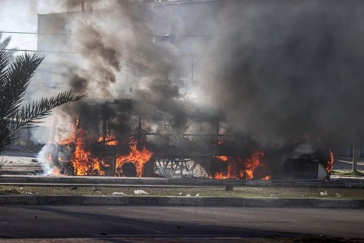 Flames and smoke rise from a bus hit by an Israeli attack in Salah al-Din Road, central Deir al Balah, Gaza.