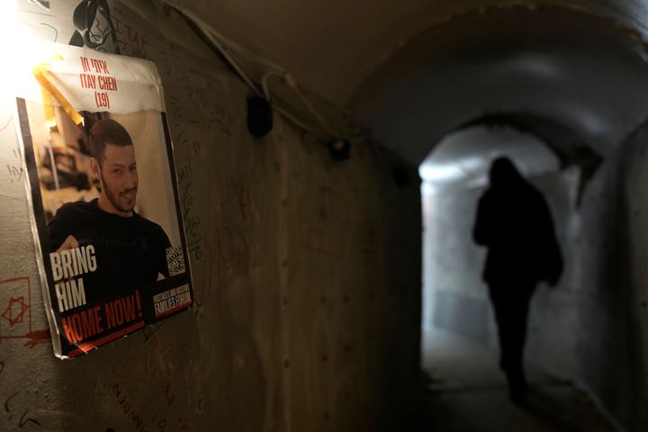 A sign showing one of the hostages taken by Hamas militants on Oct. 7th hangs on the wall as people walk through an installation simulating a tunnel in Gaza in an act of solidarity with hostages believed to be held underground in Gaza and calling for their return, in Tel Aviv, Israel, Saturday Jan. 13, 2024. (AP Photo/Leo Correa)