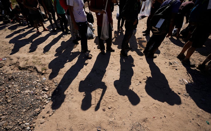 Migrants wait to be processed by the U.S. Customs and Border Patrol after they crossed the Rio Grande and entered the U.S. from Mexico, Oct. 19, 2023, in Eagle Pass, Texas. U.S. officials have accused Texas of blocking border agents from being able to access Eagle Pass in order to try and save three migrants drowning in the Rio Grande.