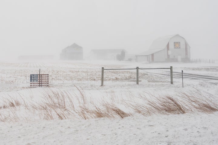 An American flag is seen fixed to a farm fence along US Highway 20 during a blizzard near Galva, Iowa, on Jan. 13, 2024.
