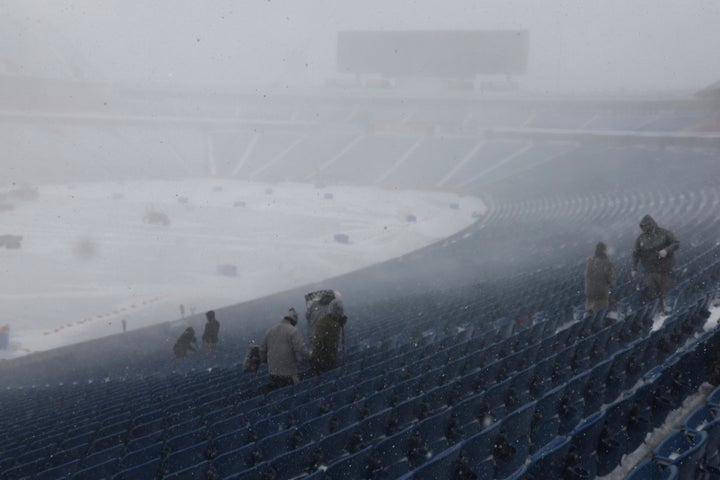 Workers remove snow from Highmark Stadium in Orchard Park, N.Y., on Jan. 14, 2024.
