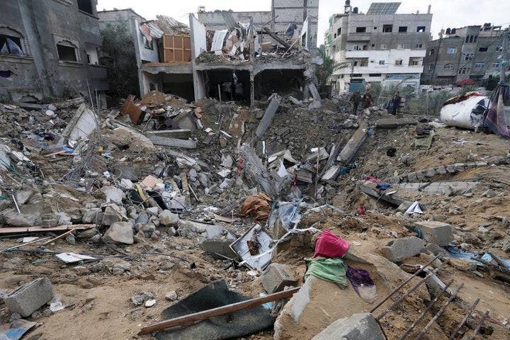 Palestinians look at the destruction after an Israeli strike at a residential building in Deir al Balah, Gaza Strip.