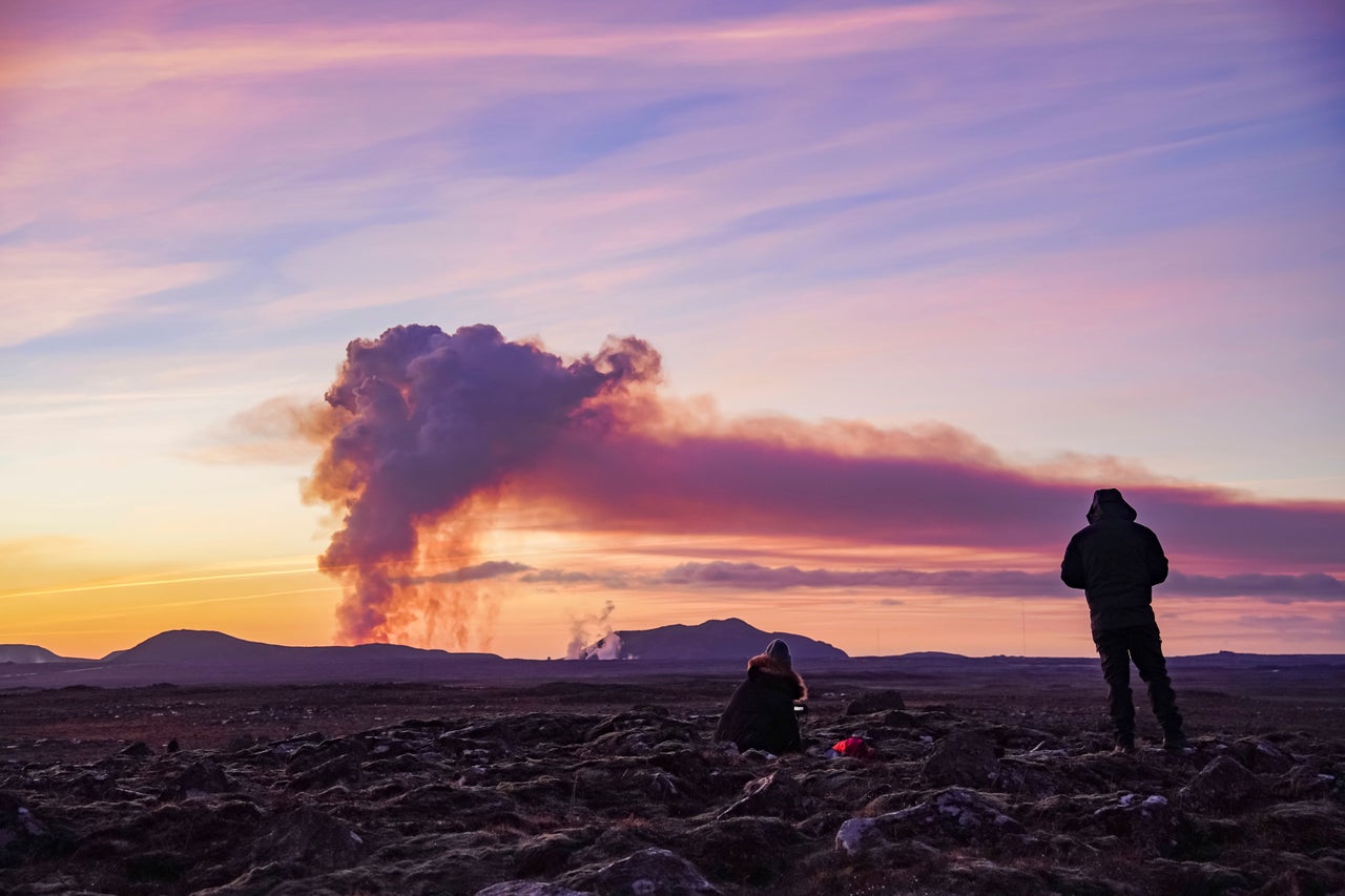 People watch from the north as the volcano erupts near Grindavík on Sunday.