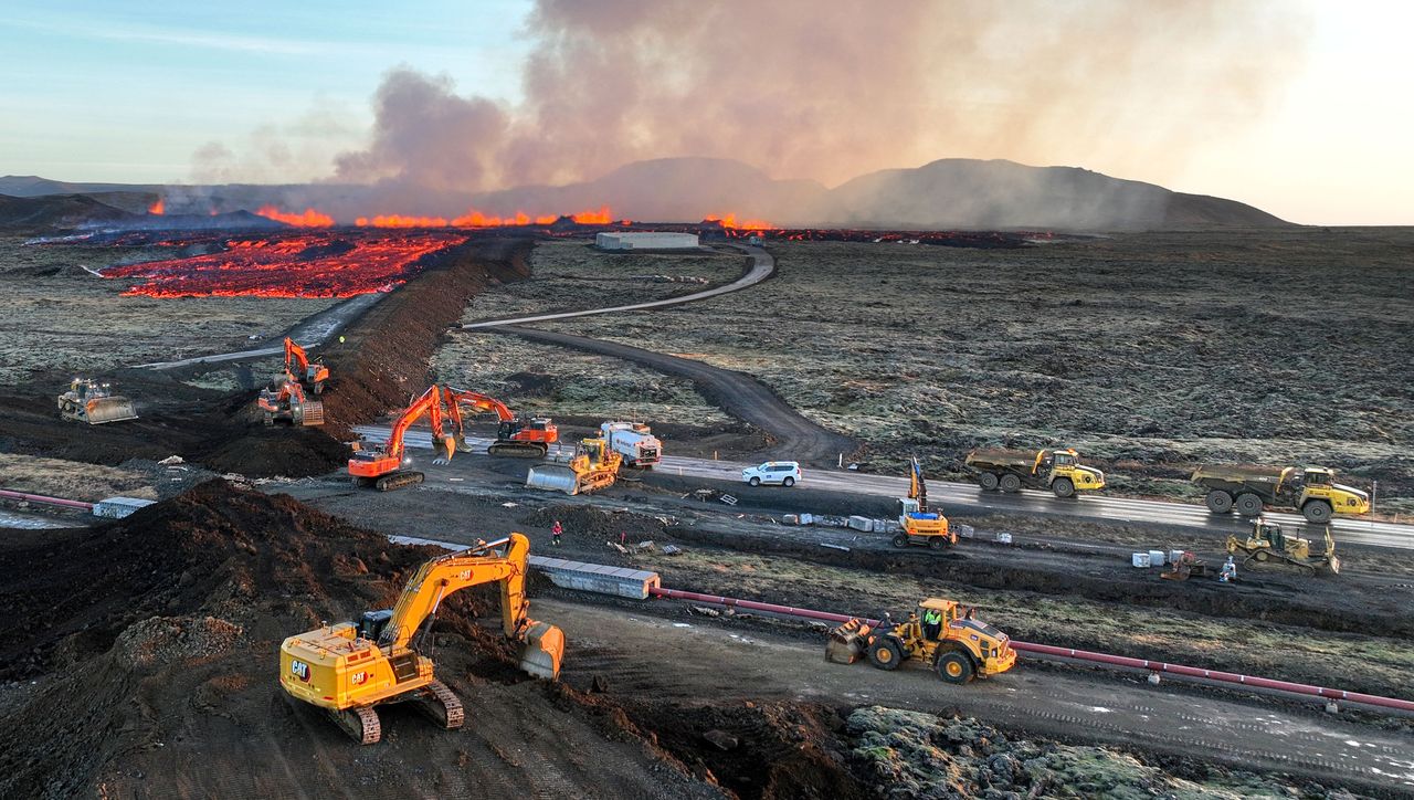 Aerial view taken on Sunday shows emergency personnel using diggers to build a protective wall trying to prevent flowing lava from reaching the town center.