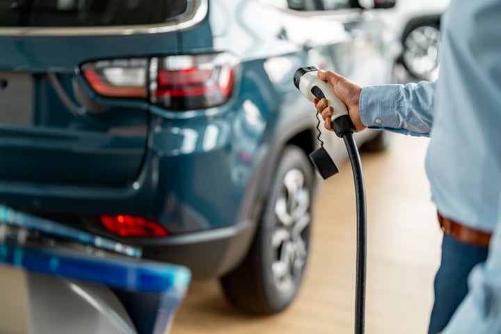 Man refueling an electric car in a garage