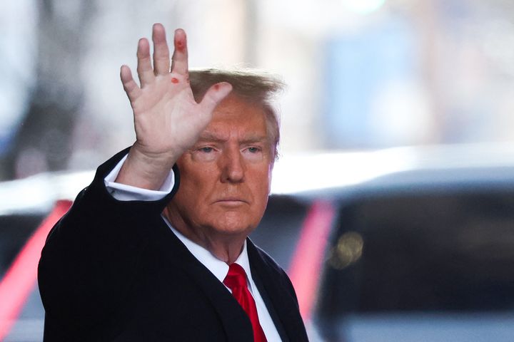 The former president is seen waving to spectators as he leaves Trump Tower for court on Wednesday. The nature of the red marks on his hand was not immediately clear.