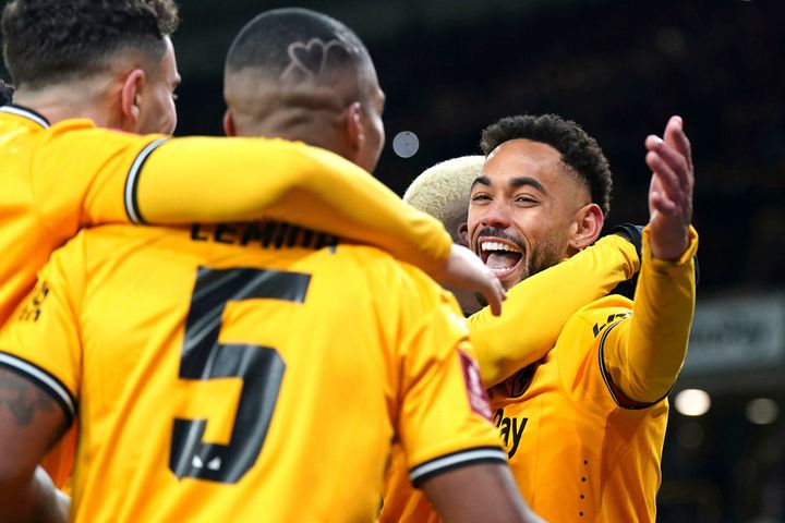 Wolverhampton Wanderers' Matheus Cunha, right, celebrates scoring their side's third goal of the game from the penalty spot with teammates in extra time during the English FA Cup third round replay soccer match between Wolverhampton Wanderers and Brentford. (Jacob King/PA via AP)