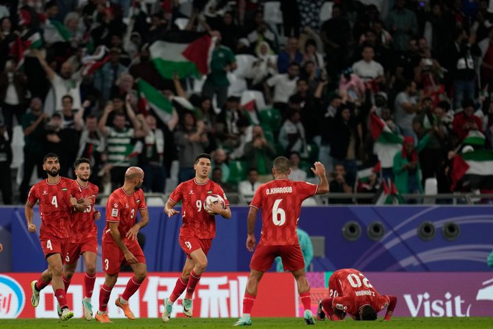 Palestinian soccer player Tamer Seyam holds the ball after scoring his team's first goal during an Asian Cup match with Iran in Al Rayyan, Qatar, on Sunday, Jan. 14.
