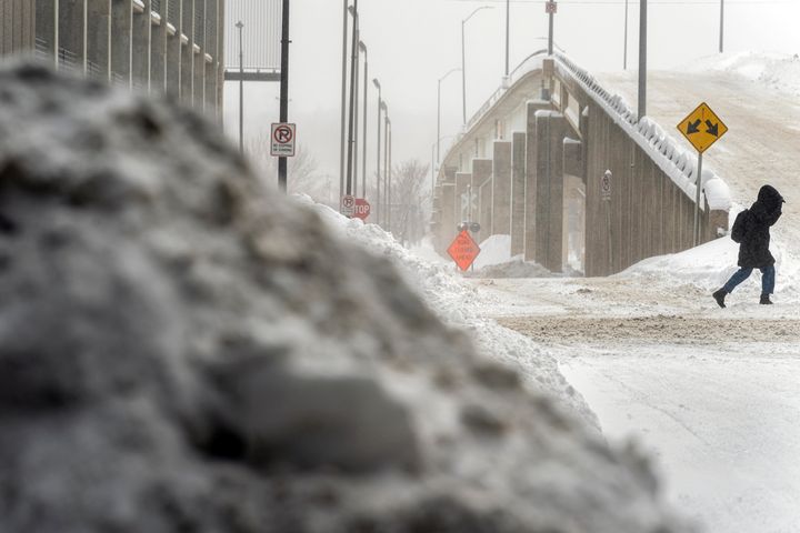 A woman walks through snow in downtown Des Moines, Iowa, Saturday, Jan. 13, 2024. (AP Photo/Andrew Harnik)