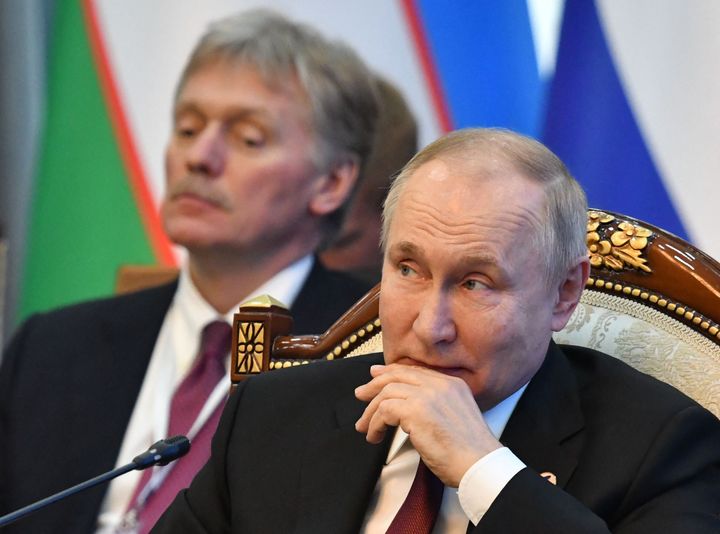 Russia's president Vladimir Putin (R) and his spokesman Dmitry Peskov (L)