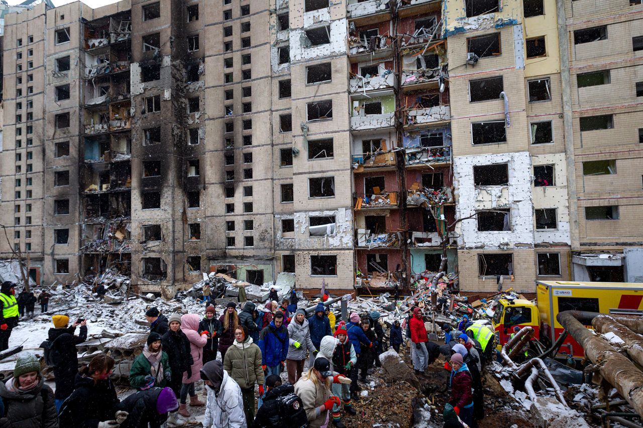 Residents remove rubble outside an apartment building destroyed by a Russian missile attack the day prior, in Kyiv, Ukraine, on Jan. 3, 2024.