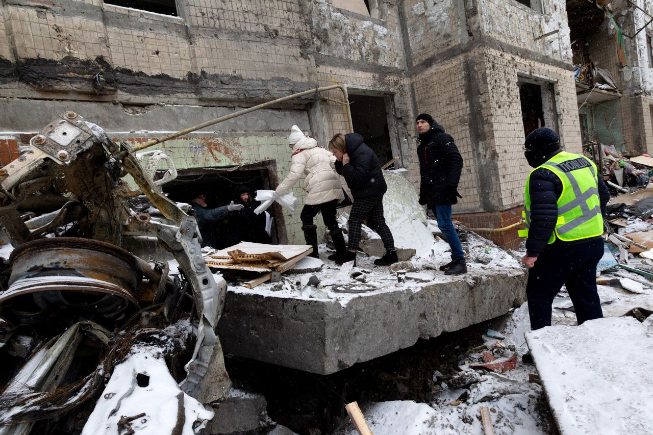 People move past a collapsed wall as they attempt to get inside an apartment building destroyed in the Russian missile attack the day prior in Kyiv, Ukraine, on Jan. 3, 2024.