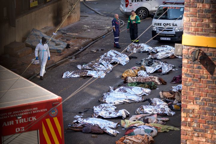 Γιατροί στέκονται δίπλα στα σκεπασμένα πτώματα των θυμάτων μιας φονικής πυρκαγιάς στο κέντρο του Γιοχάνεσμπουργκ, Πέμπτη, 31 Αυγούστου 2023. Ένας άνδρας έκανε τον συγκλονιστικό ισχυρισμό ότι αυτός προκάλεσε την πυρκαγιά σε πολυκατοικία στη Νότια Αφρική που σκότωσε 76 ανθρώπους πέρυσι, όταν έβαλε φωτιά στο πτώμα ενός ατόμου που είχε στραγγαλίσει στο υπόγειο του υποβαθμισμένου συγκροτήματος διαμερισμάτων. Τα νοτιοαφρικανικά μέσα ενημέρωσης μετέδωσαν ότι ο αιφνιδιαστικός ισχυρισμός του άνδρα έγινε όταν κατέθετε την Τρίτη 23 Ιανουαρίου 2024 σε έρευνα που διεξάγεται για την καταστροφή.