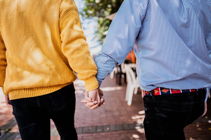 Rear view of traveler gay couple walking in the street