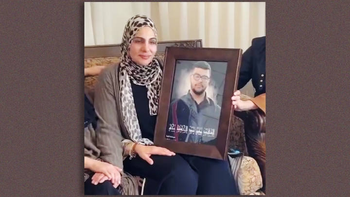 Abdeljabbar's mother holds a photo of the teen after he was killed in the West Bank.