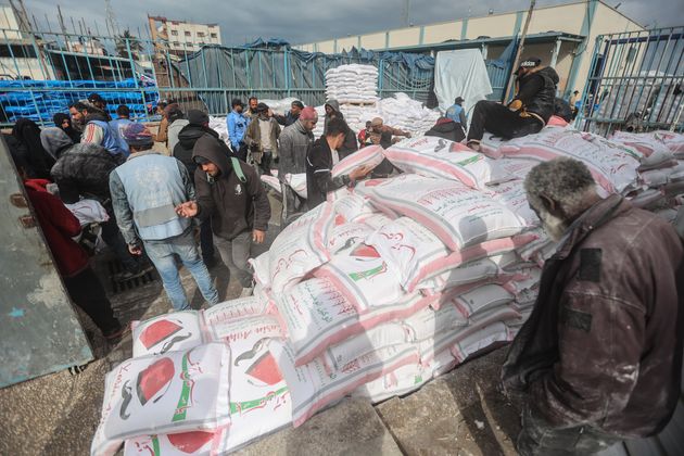 南部ラファで、UNRWAが配布した小麦粉を各家庭に配るパレスチナ人。ガザ市民は深刻な水不足と食糧不足に直面している（2024年1月28日）