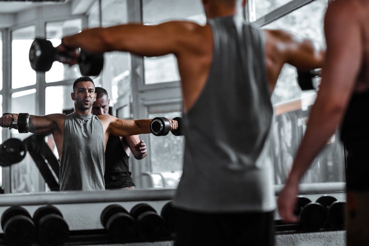 Chest Exercises Done By Athlete With The Help Of Fitness Instructor