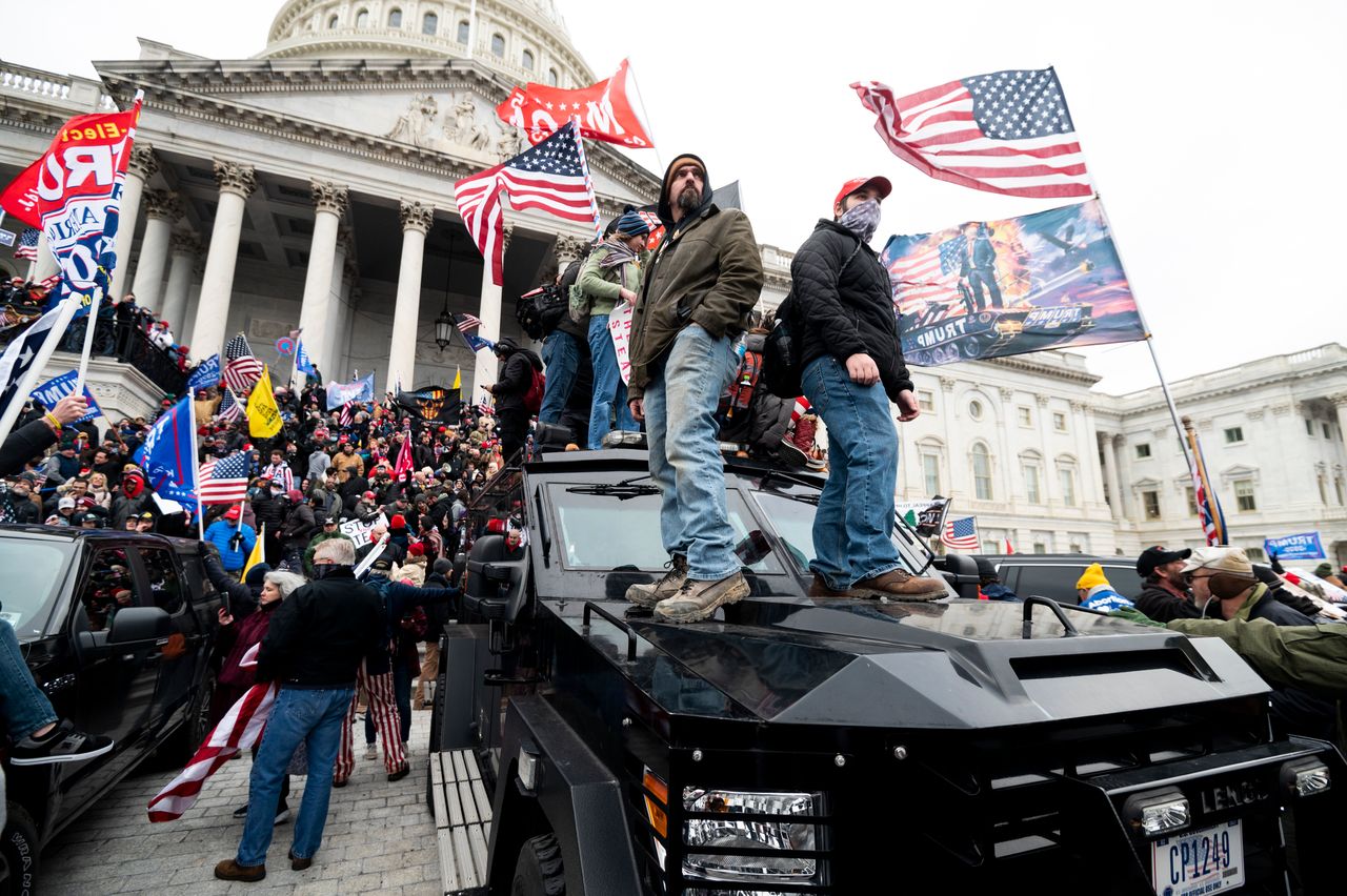 Trump supporters stand on the U.S. Capitol Police armored vehicle as others take over the steps of the Capitol on Jan. 6, 2021.