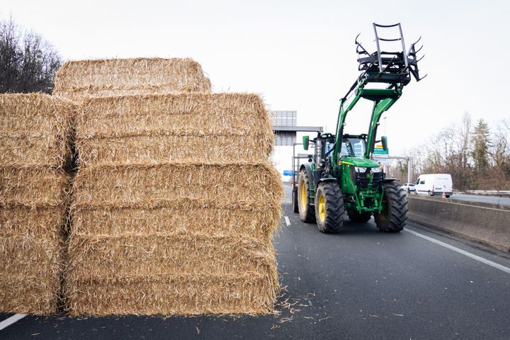 A tractor and a tower of hay bales block the A15 highway on Jan. 29.