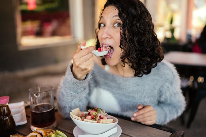 Latin woman enjoying a plate of ceviche in a restaurant
