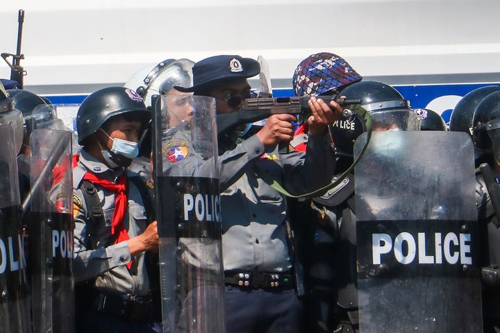 ミャンマーの首都ネピドーで、国軍によるクーデターに抗議するデモ隊と衝突した際、銃を向ける警官（2021年2月9日撮影）