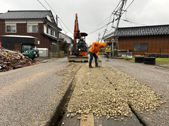 路面の亀裂を埋めるボランティア